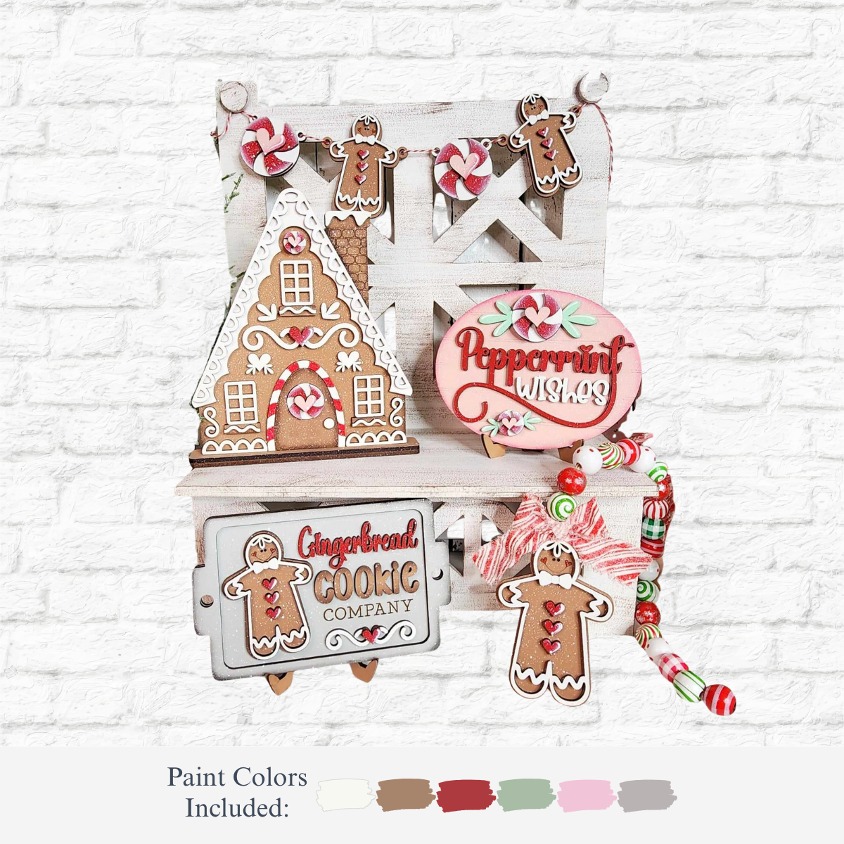 The Rustic Rhode DIY Gingerbread Tiered Tray Kit includes laser-cut Baltic Birch pieces like a gingerbread house, cookies, “Peppermint Wishes,” “Gingerbread Cookie Company” signs, and garland for festive decor. Paint colors are shown below.