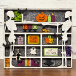 Tales From The Nook: Falls & Frights by The Rustic Rhode is a Halloween shadow box inspired by a DIY Book Nook, featuring white skeletons, bats, pumpkins, candles, moss, and Boo/Trick or Treat/Happy Halloween signs with spooky icons.
