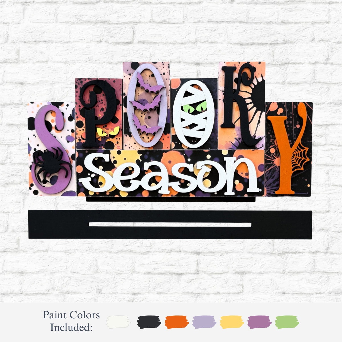 The Rustic Rhode’s DIY Spooky Season Word Block features colorful bat, mask, spider, and web accents—perfect for your Warwick RI crafting workshop or as a festive Halloween project with vibrant splattered paint designs.
