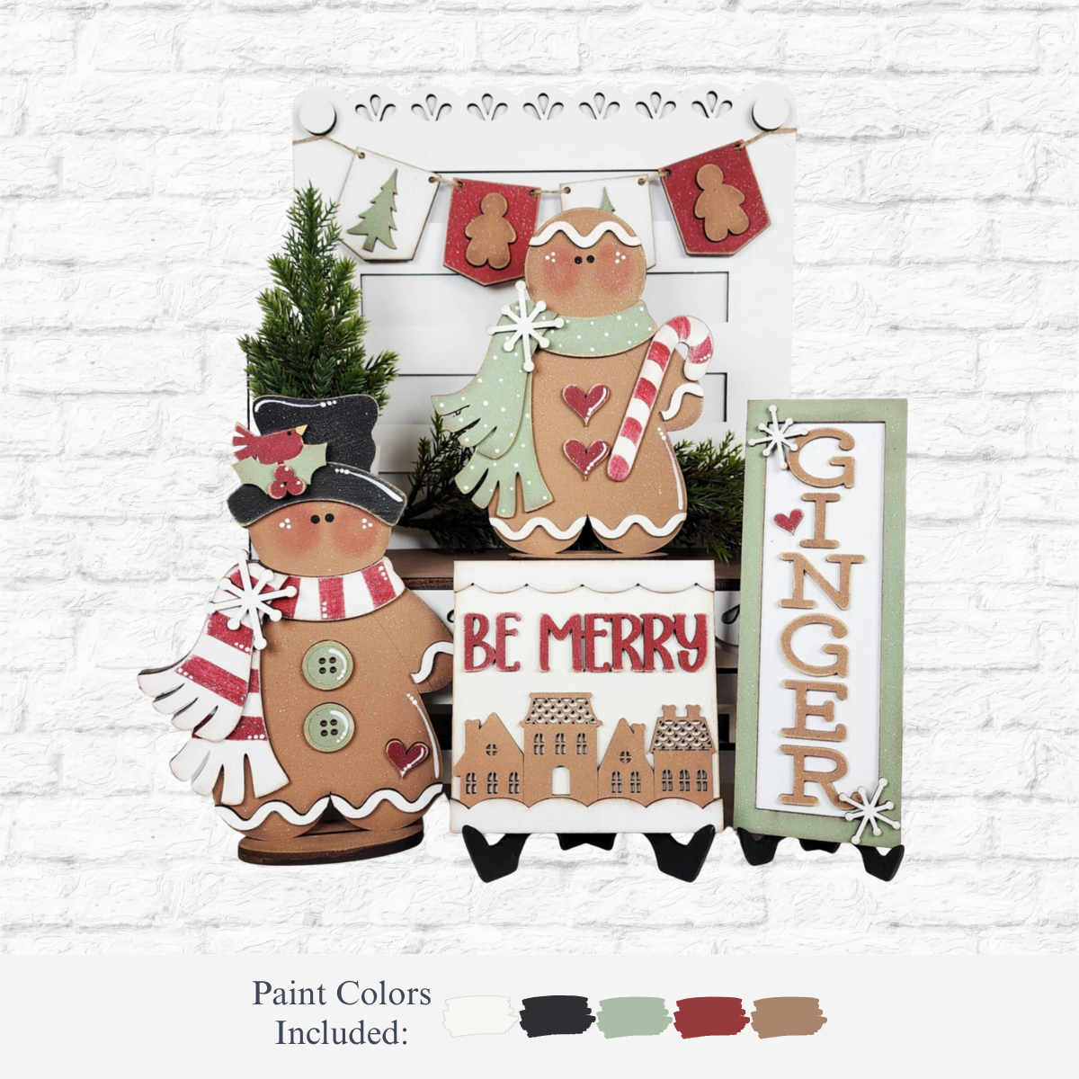 A festive display using The Rustic Rhode’s DIY Victorian Gingerbread Tiered Tray Kit features gingerbread figures, a tree, “Be Merry” and “Ginger” signs, plus mitten garland on a white brick background. Paint colors shown below.