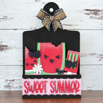 The Rustic Rhode DIY Watermelon Summer 2 Piece Insert features watermelon slices, black birds, ants, flowers, and a red spatula on a black board with plaid bow. “SWEET SUMMER” in bold pink letters accents the decorative sign.