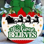 Celebrate the season with The Rustic Rhode's Set The Barre Fundraiser-October 25th: a festive DIY door hanger kit featuring a green bow, greenery, Santa's sleigh silhouette, and "This House Believes" for holiday cheer!.