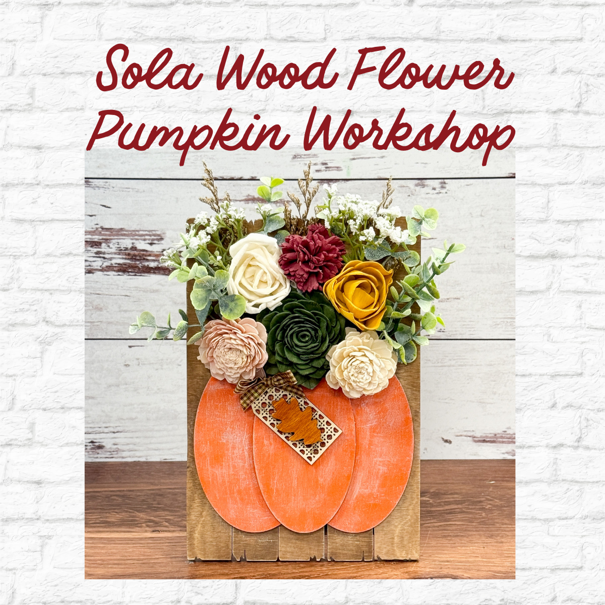 The Rustic Rhode’s Sola Wood Flower Pumpkin Workshop features a wooden box with an orange pumpkin cutout, filled with assorted sola wood flowers and greenery, against a white brick background.